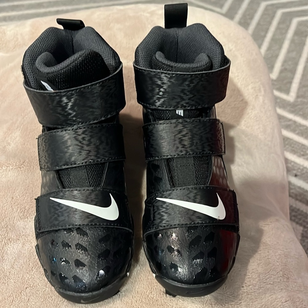 New NIKE boys black cleats
Size 1   3/4 Ankle 
BRAND NEW never worn